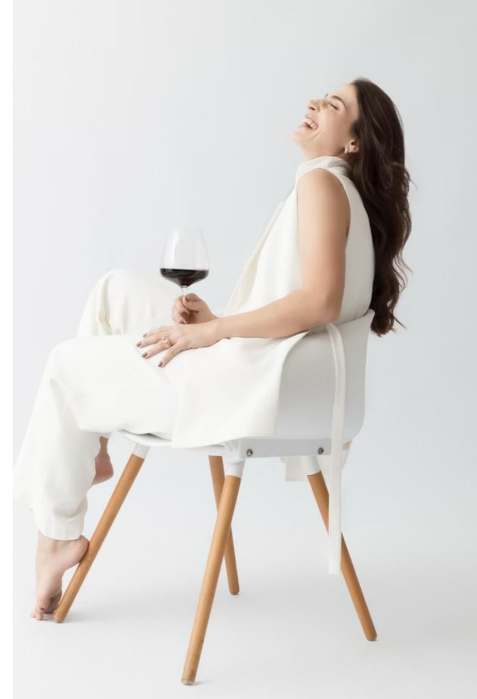 Cláudia Navarro, sommelière, sentada com uma taça de vinho tinto